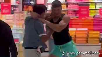 Wild moment middle-aged woman steps in to break up a vicious fight between two young men that erupted outside a scented candle shop