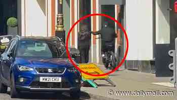 Moment thief on e-bike snatches phone from woman's hands as she walks down central London pavement on a Sunday morning