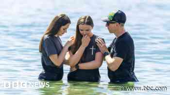 Hundreds gather on beach for mass baptisms in sea