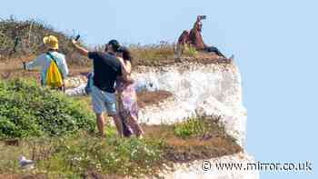 Birling Gap tourists pictured dicing with death at the edge of crumbling clifftop in heatwave
