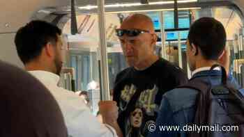 Moment Elizabeth line passengers rush to man's defence after he is slapped by insult-hurling stranger on busy carriage - then force attacker to apologise