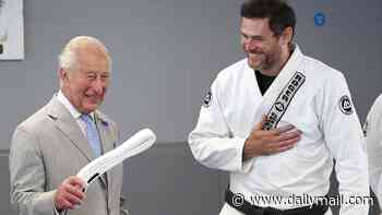 Jiu Jitsu King! Charles is given a white belt - and some plastic overshoes - during heatwave visit to London martial arts charity