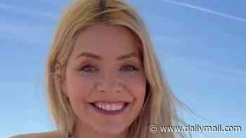 Holly Willoughby poses in a plunging swimsuit as she hits the beach during UK heatwave ahead of the re-launch of her presenting career
