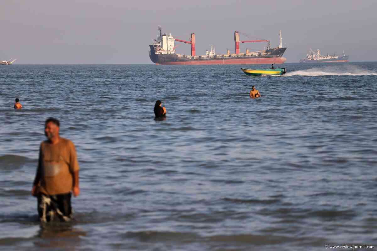 British military says a cargo ship was hit while moving through the Strait of Hormuz