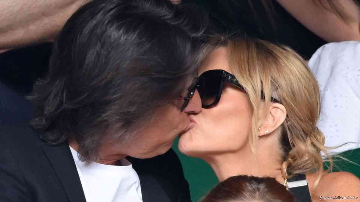 Amanda Holden shares a passionate kiss with husband Chris Hughes in the stands after tucking into champagne during day one of Wimbledon