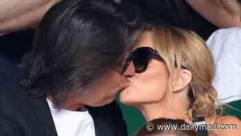 Amanda Holden shares a passionate kiss with husband Chris Hughes in the stands after tucking into champagne during day one of Wimbledon