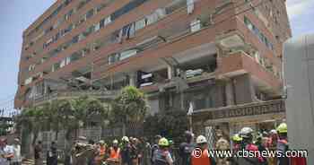 Rescuers in Venezuela race to save security guard trapped under building