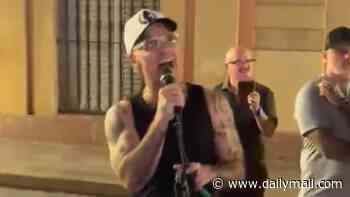 Robbie Williams stuns Spanish locals as he joins a busker with a surprise performance of his hit song Angels in the streets of Seville