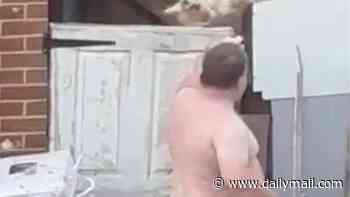 Shocking moment shirtless thug grabs a terrified dog by the head and flings it over a 6ft fence