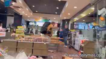 Wild moment angry customer smashes his guitar at an Adelaide service station as bystanders watch foul-mouthed outburst in shock