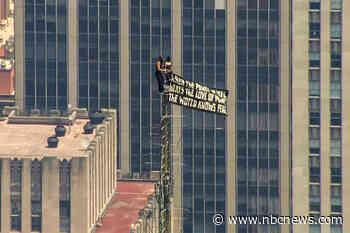 Two people scale Empire State Building to fly peace banner and kiss