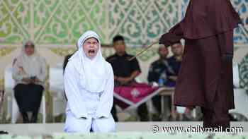 Woman passes out as she becomes the first ever to be caned for 'committing obscenity live with a man on social media' under Indonesian province's Sharia law