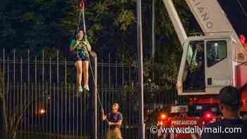 Woman is rescued by crane after getting stuck on a fence trying to sneak into World Cup fans area