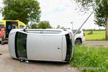 Auto op zijkant na botsing, vier personen nagekeken