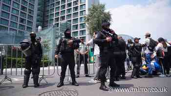 Police in riot gear guard England hotel ahead of Mexico clash as hundreds gather outside