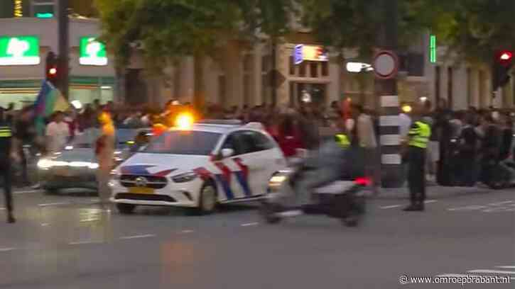Scooterrijder let niet op tussen feestende supporters en knalt tegen auto