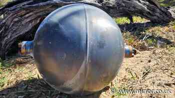 Beach sealed off after six mysterious metal balls appear on sand