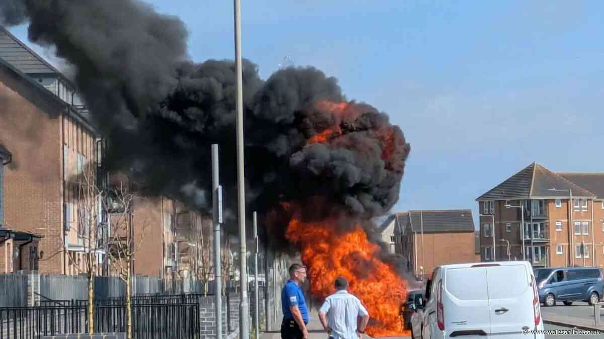 Parked car engulfed in flames as thick smoke rises over street