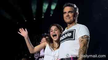 Robbie Williams brings his rarely seen daughter Teddy, 13, on stage in Luxembourg during his Britpop Tour - after revealing she is set to follow in his footsteps with her 'wonderful voice'
