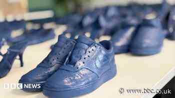 Why are 150 pairs of blue shoes on display in seaside resort?