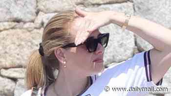 Adele shows her support for footballer John Stones by wearing a number five England shirt while in Sardinia with fashion designer Tom Ford