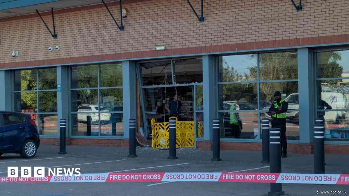 Shop evacuated after car smashes through front