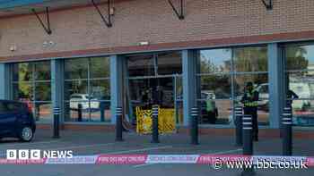Shop evacuated after car smashes through front