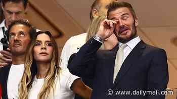 David Beckham wipes away his nerves as he watches England take on Argentina in tense first half with wife Victoria and family