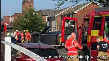 Firefighters rescue couple from car after it rolled onto its side in Royton
