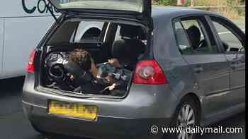 Now that's real air conditioning! Car passenger keeps boot open to stay cool as he is driven along the M25