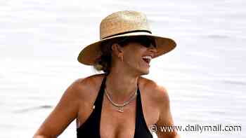 Pregnant Vogue Williams shows off her baby bump in a black bikini as she enjoys a relaxing dip in Spain after sharing her prenatal workout regime