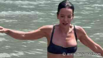 Lily Allen stuns in a barely-there bikini as she enjoys a swim in the sea during her European getaway