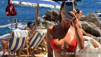 Dina Broadhurst wears a very revealing red G-string bikini during a beach outing in Capri with her son and his girlfriend