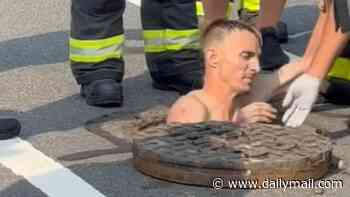 Bewildered rescue workers spend half an hour struggling to pull shirtless man from Philadelphia manhole