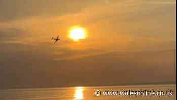 Stunning moment plane flies over Welsh beach at sunset