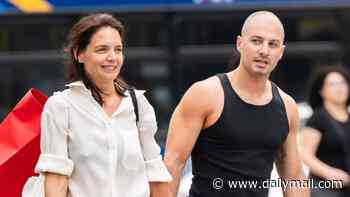 What a gentleman! Katie Holmes' buff toyboy Jason Bard Yarmosky shows off his muscles as he carries her purse in NYC