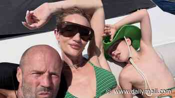 Bikini-clad Rosie Huntington-Whiteley cosies up to fiancé Jason Statham in rare family holiday snaps while their son Jack, 9, proves he's just like his action hero dad as he jumps off yacht