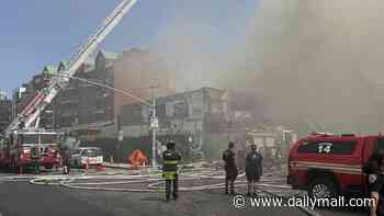Nearly two dozen people injured as monster fire rips through wooden apartment block leaving resident trapped