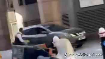 Moment driver swerves past police in chase before crashing and 'spinning around' in front of shopping centre - as injured man and woman are arrested