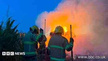 Dozens of firefighters battle huge hay fire
