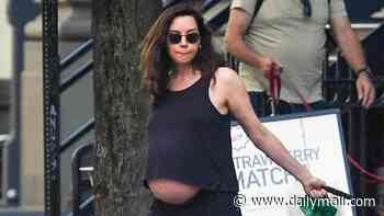Aubrey Plaza embraces her baby bump as she bares her blossoming midsection in tank top during NYC stroll
