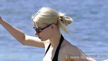 Skipping to the seaside! Anya Taylor-Joy sports a black bikini and buttoned shirt as she enjoys paddleboarding with her husband Malcolm McRae
