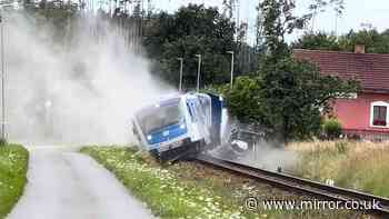 Train smashes through lorry at level crossing and derails in horror footage