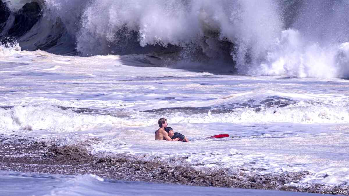Lifeguard battles massive waves to rescue a child | The Moment