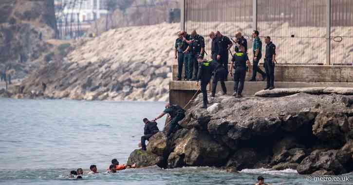 Thousands of migrants storm onto Spanish beach after overwhelming police