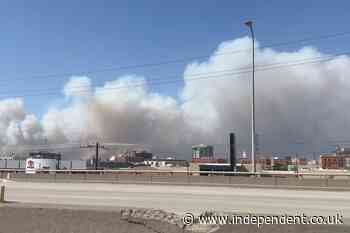 Residents flee fast-moving Washington wildfire as officials investigate what started it