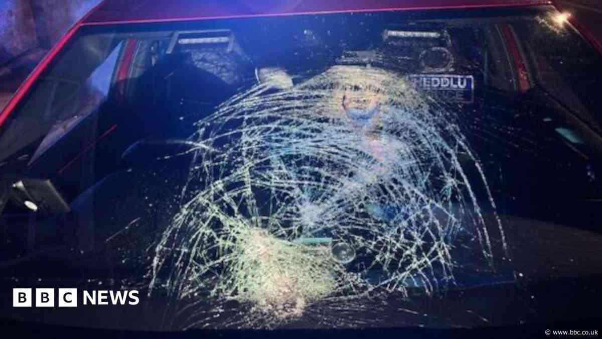 The moment glass bottles are thrown at police car on its way to emergency call