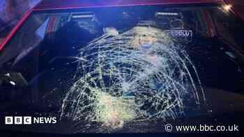 The moment glass bottles are thrown at police car on its way to emergency call