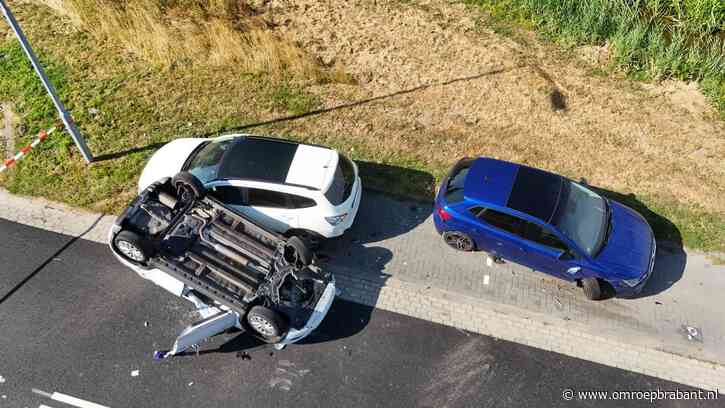 Auto ramt geparkeerde auto's en slaat over de kop, bestuurder gewond