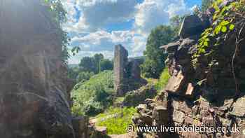 Ancient Cheshire castle ruins with footbridge, famous setting and Welsh mountain views